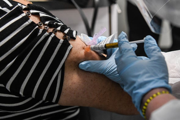 Gloved healthcare worker administers vaccine in patients arm