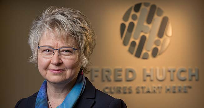 Photo of Garnet Anderson in front of Fred Hutch logo