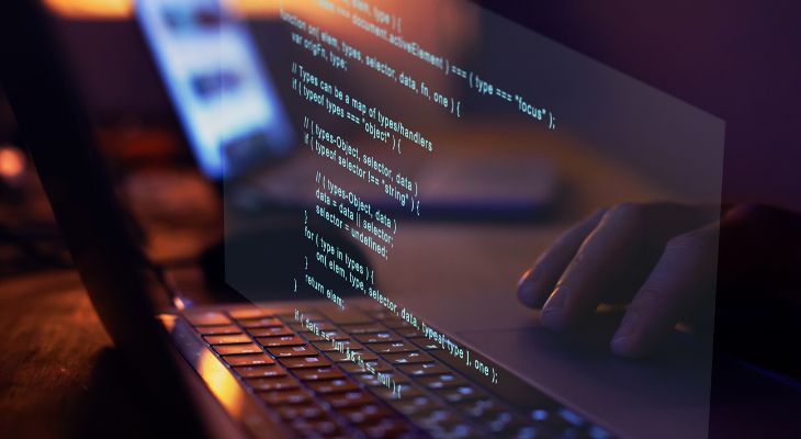 Hand reflected in laptop screen being used to write code