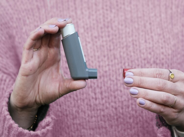 Close up of hands holding an inhaler