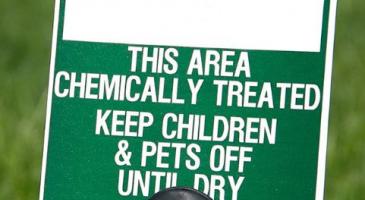 Lawn sign that says This Area Chemically Treated Keep Children and Pets Off Until Dry