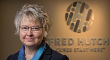 Photo of Garnet Anderson in front of Fred Hutch logo