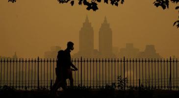 People walk in Central Park fire haze on Wednesday.