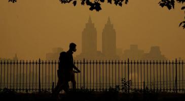 People walk in Central Park fire haze on Wednesday.