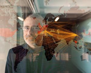Photo of Alessandro Vesignani with transparent overlay of virus modeling graph