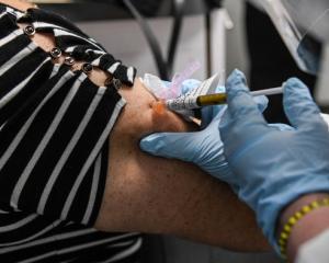Gloved healthcare worker administers vaccine in patients arm