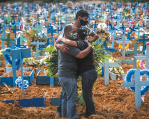 A family stands at the grave of a relative who died from COVID-19 in Manaus, Brazil, in May 2020. Photo by Andre Coelho/Getty