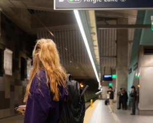 Photo of lone student waiting on light rail platform