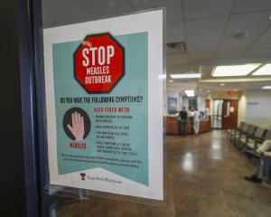 A sign warning of measles is posted on a glass door as a patients wait in the family medicine wing of at the Texas Tech Physicians of the Permian Basin Monday, Feb. 24, 2025, in Odessa, Texas. (AP)