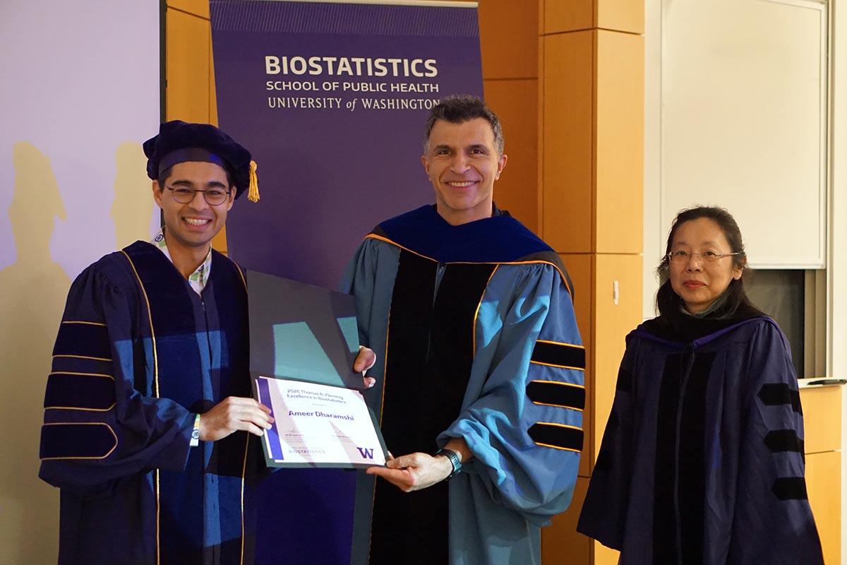 Ameer Dharamshi holds award, pictured with Ali Shojaie and Lurdes Inoue